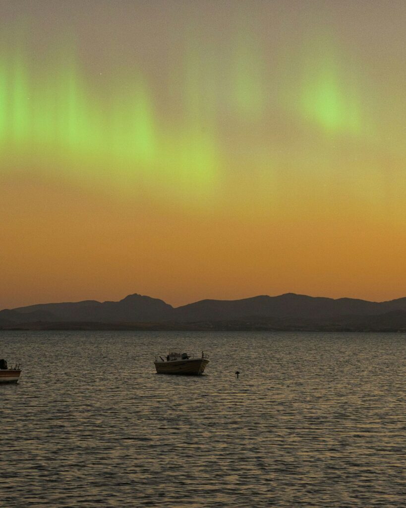 Silhueta de praticante de stand up paddle recortada contra pôr do sol em tons quentes