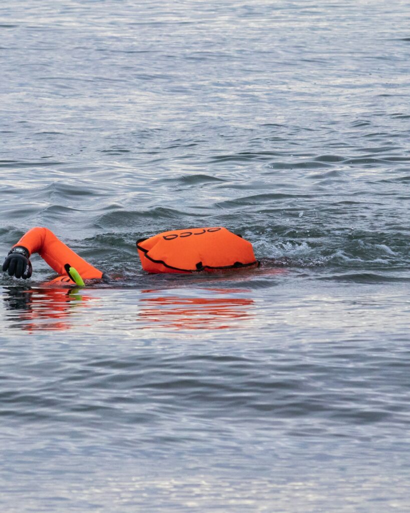 Colete salva-vidas laranja em primeiro plano à beira d'água — segurança antes de entrar no barco
