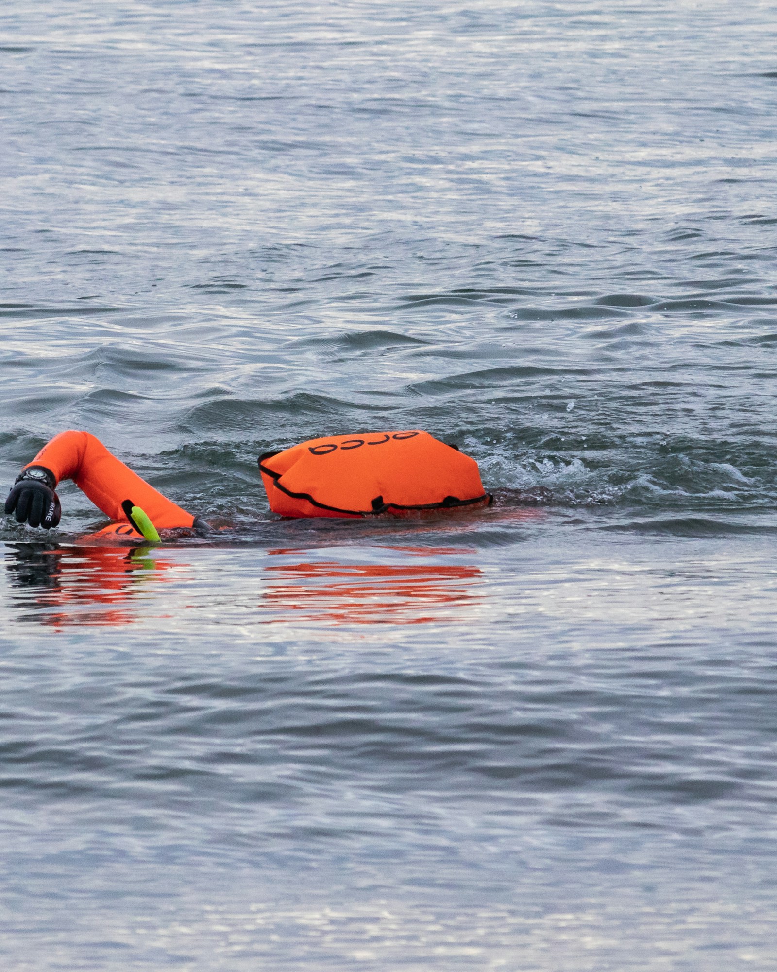 Colete salva-vidas laranja em primeiro plano à beira d'água — segurança antes de entrar no barco