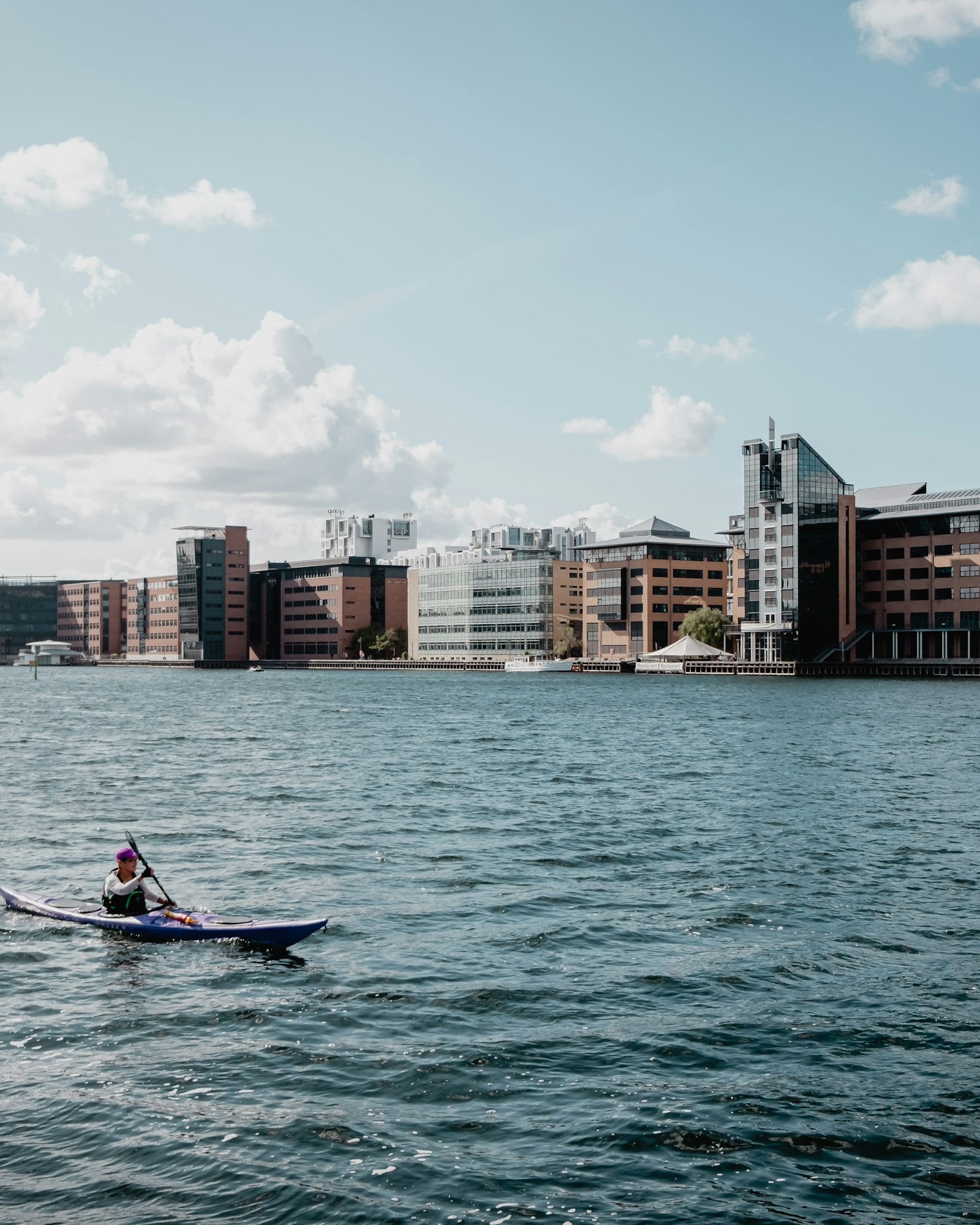 Grupo pequeno em contraluz na margem aprendendo a remar em manhã clara — turma Capital do Remo