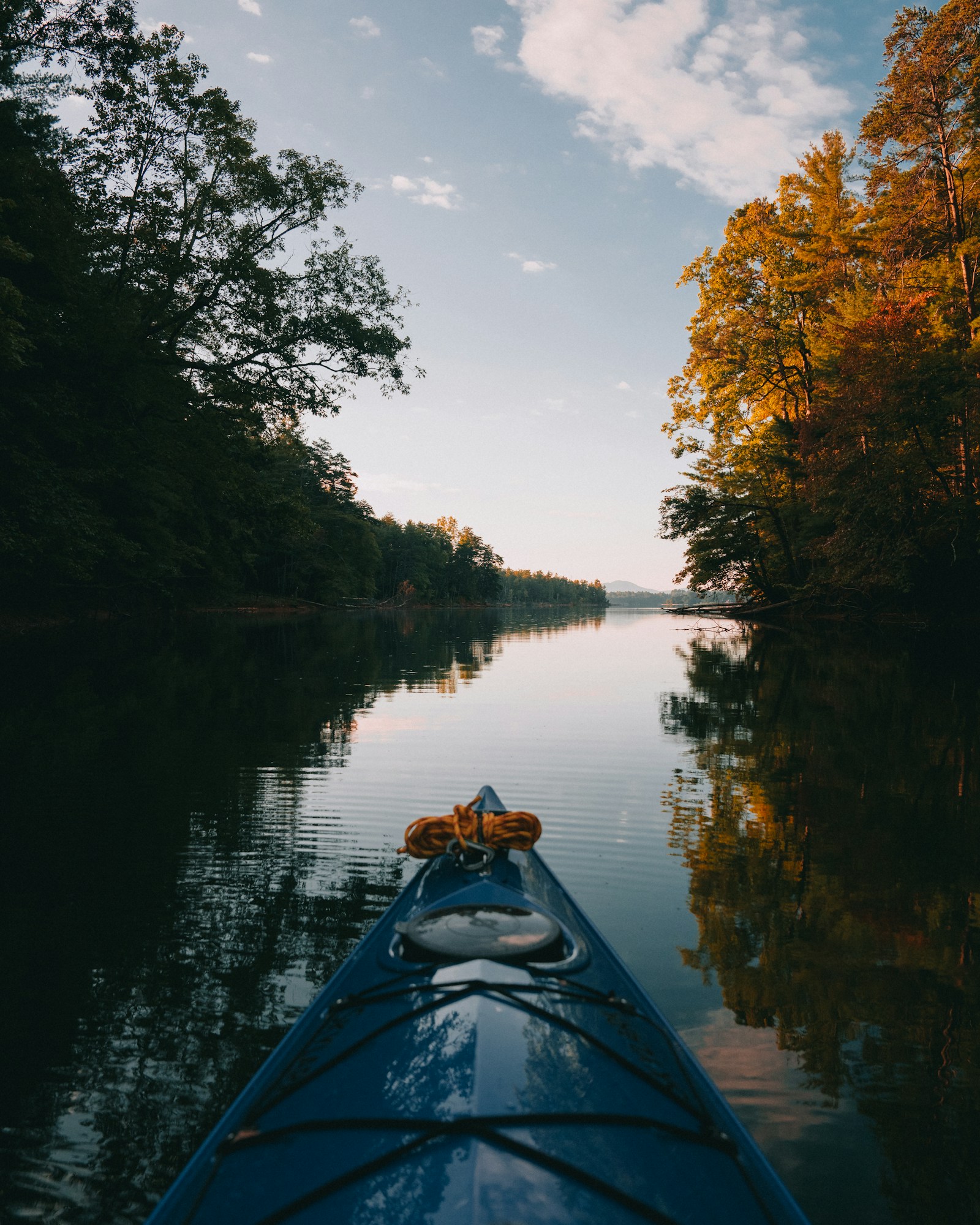 Canoa em movimento atravessa canal entre margens verdes, travessia do Tororó